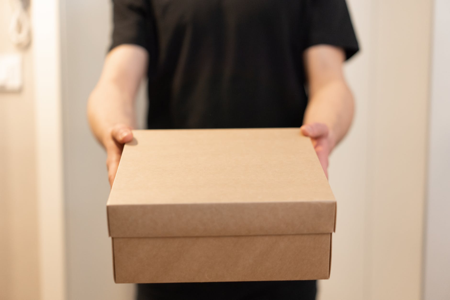 a person in black shirt holding a box