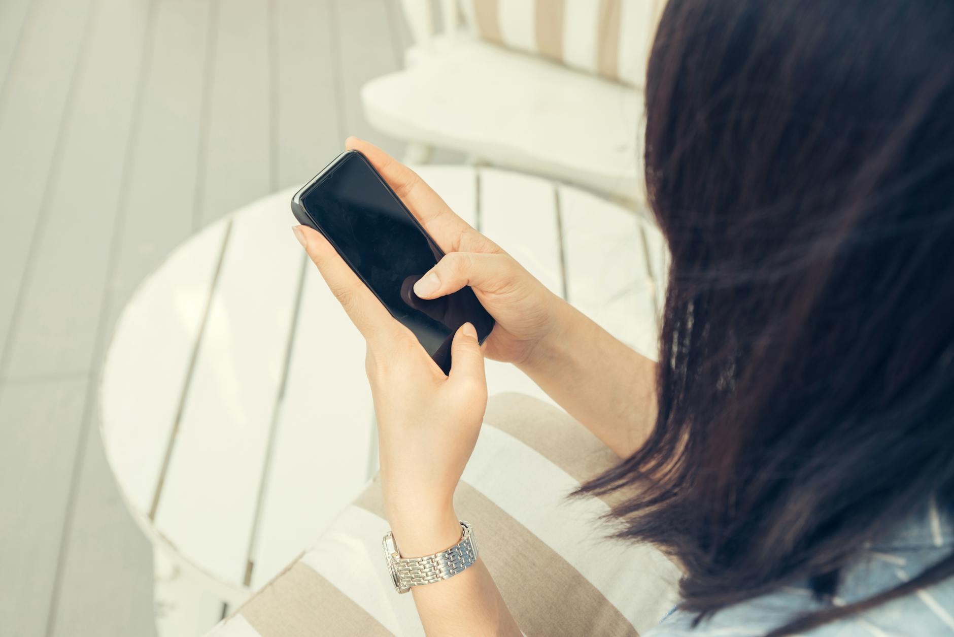 woman holding black smartphone